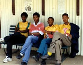 4 young men sitting on a bench